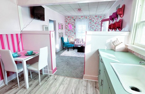 Russell Apartment | Rhinestone Cowgirl is a chic pink-inspired upper-level apartment just blocks from downtown Russell. Enjoy a cozy bedroom, living area with Smart TV, kitchenette, full bath, private balcony, and shared backyard with grill, firepit, and laundry.