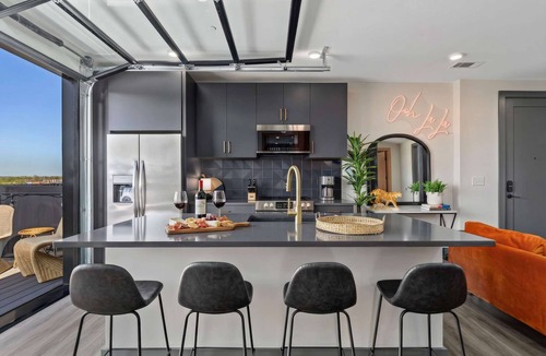 Rolling Mill Hill Apartment | Summer rooftop deck, skyline views, garage-door kitchen near Broadway