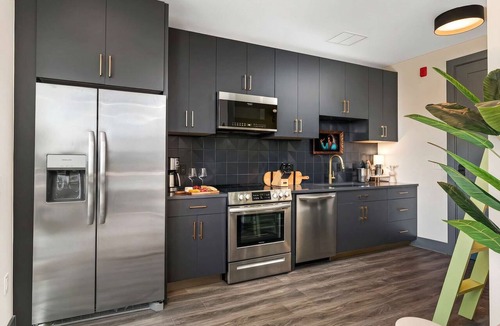 Rolling Mill Hill Apartment | Summer rooftop deck, skyline views, glass garage door near Broadway